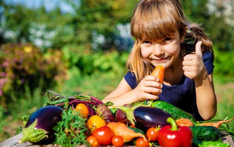 כיצד לגרום לילדים לאהוב מזון בריא? - בתמונה ילדה אוכלת ירקות בשמחה