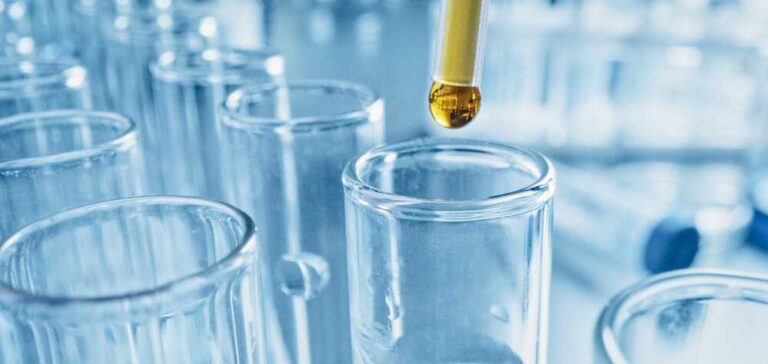 חיסון פוליו - האם הוא באמת יעיל ובטוח? - בתמונה מבחנות במעבדה וטיפה צהובה שמטפטפים לאחת מהן
