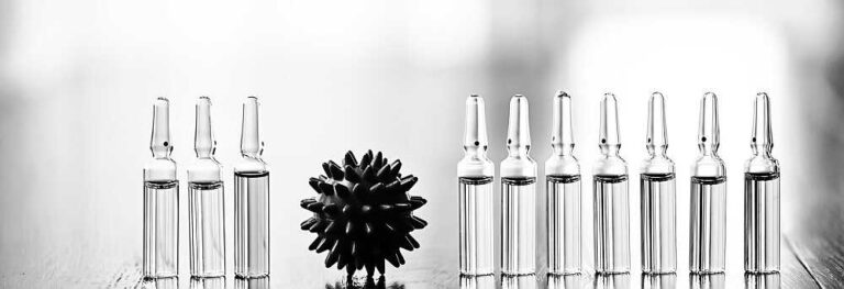 חיסונים ללא כל צנזורה - חלק ה' - בתמונה בקבוקונים מלאים בתמיסה שקופה על שולחן בצעבדה וביניהם עיגול דמוי נגיף